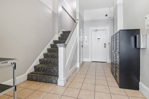 Apartment foyer with stylish decor, stairs, and mailboxes