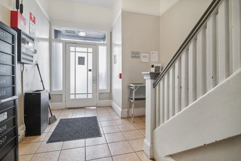 Apartment foyer with stylish decor, stairs, and mailboxes