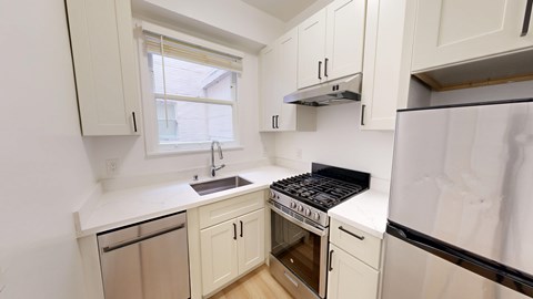 A kitchen with white cabinets and a black stove top oven.