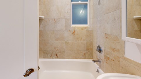 A bathroom with a white tub and a door.