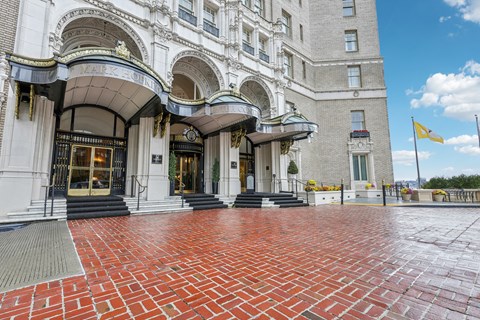 The front of a building with a red brick walkway in front.