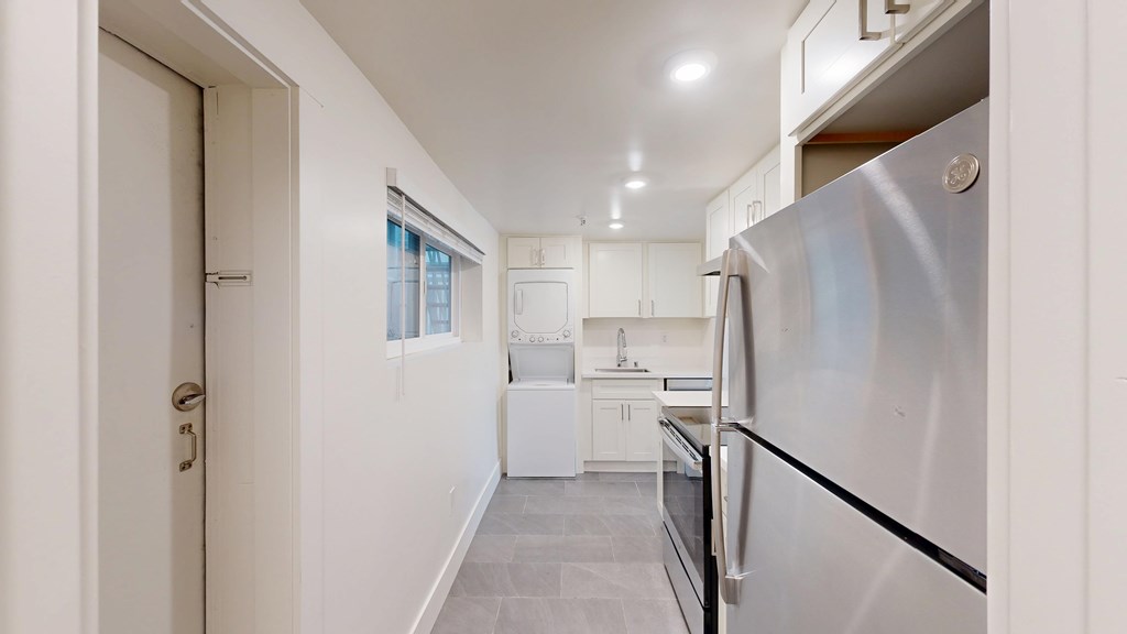 A modern kitchen with a refrigerator on the right side.