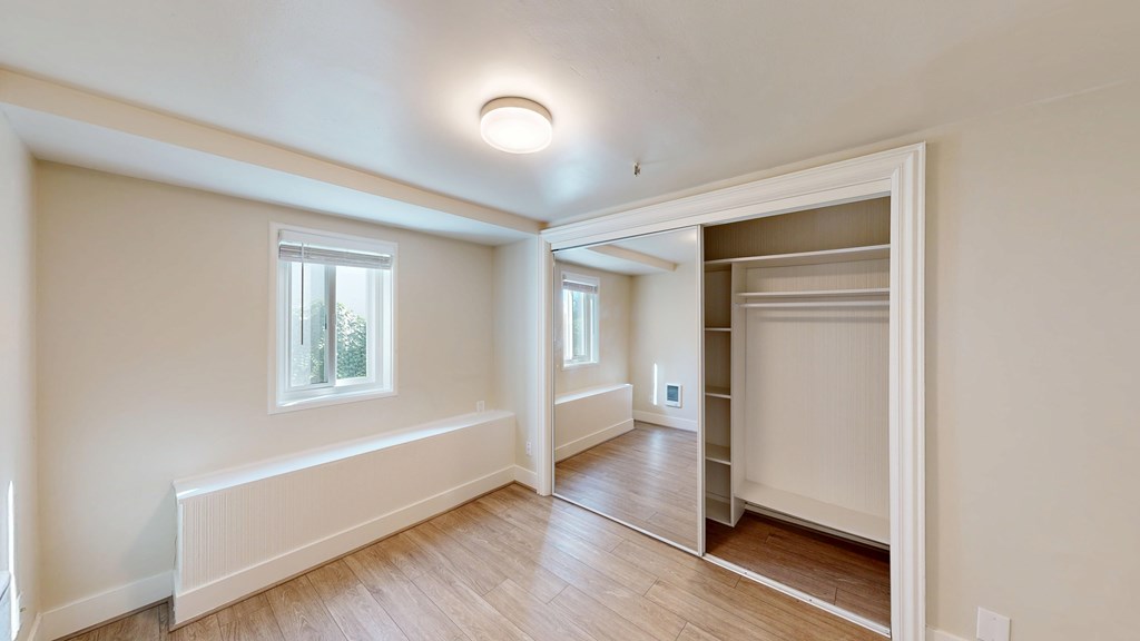 A room with a window and a door leading to another room.