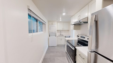 A modern kitchen with stainless steel appliances and white cabinetry.