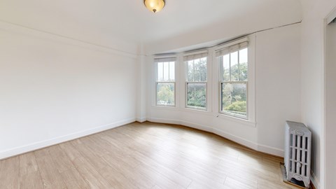 A room with a white wall and a window with a white frame.