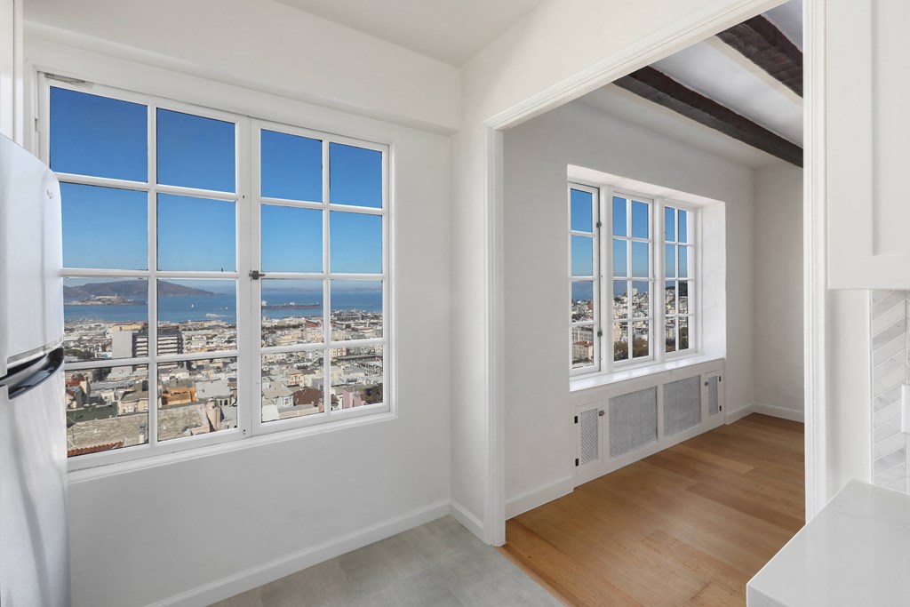 a living room with large windows and a view of the city