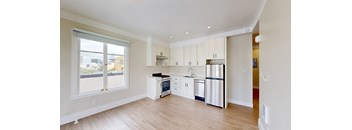 a kitchen with white cabinets and a stainless steel refrigerator