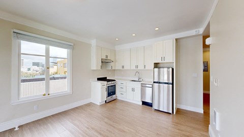 a kitchen with white cabinets and a stainless steel refrigerator