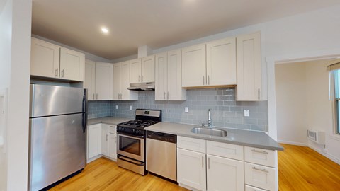 A kitchen with a stainless steel refrigerator, stove, and oven.