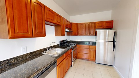 A kitchen with wooden cabinets and a stainless steel refrigerator.