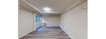 the living room of a house with white walls and a window
