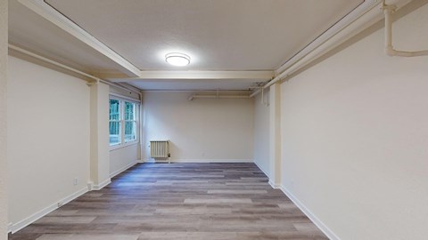 the living room of a house with white walls and a window