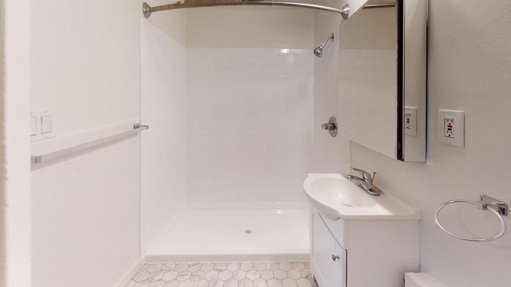 a white bathroom with a shower and a sink