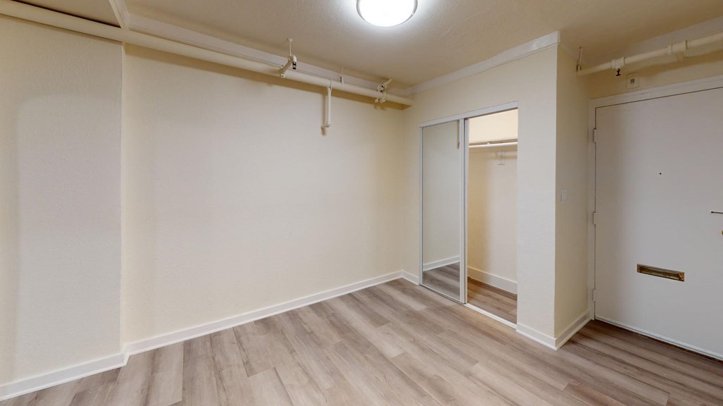 an empty room with white walls and a door to a closet