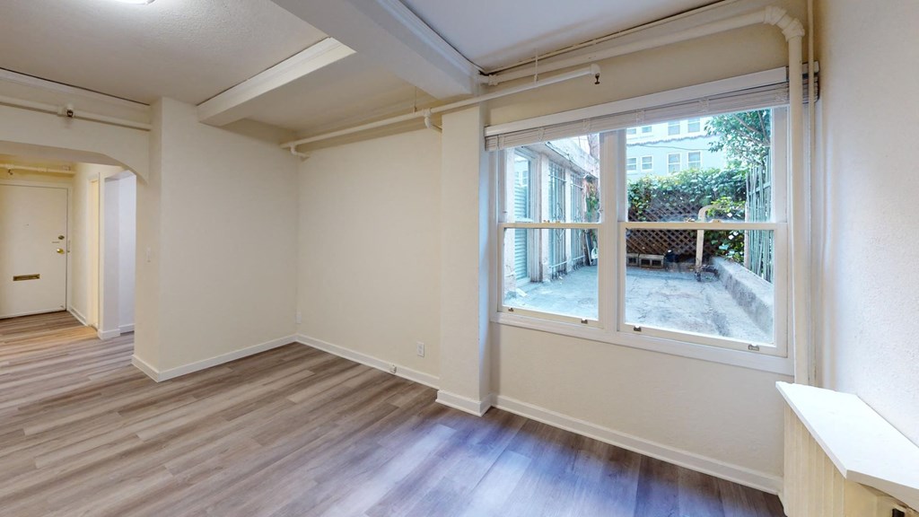 a living room with a large window and wooden floors
