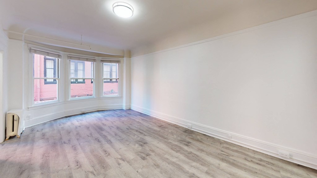 an empty living room with white walls and wood floors