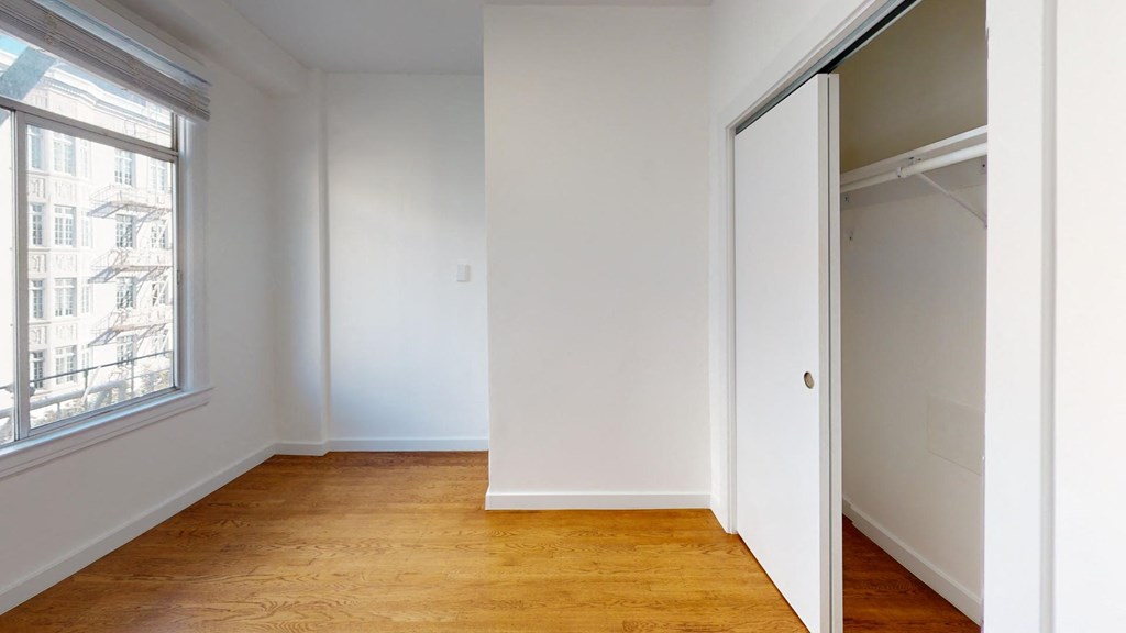 a bedroom with a closet and a large window