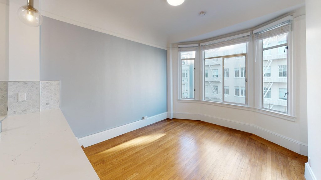 an empty living room with wood floors and windows