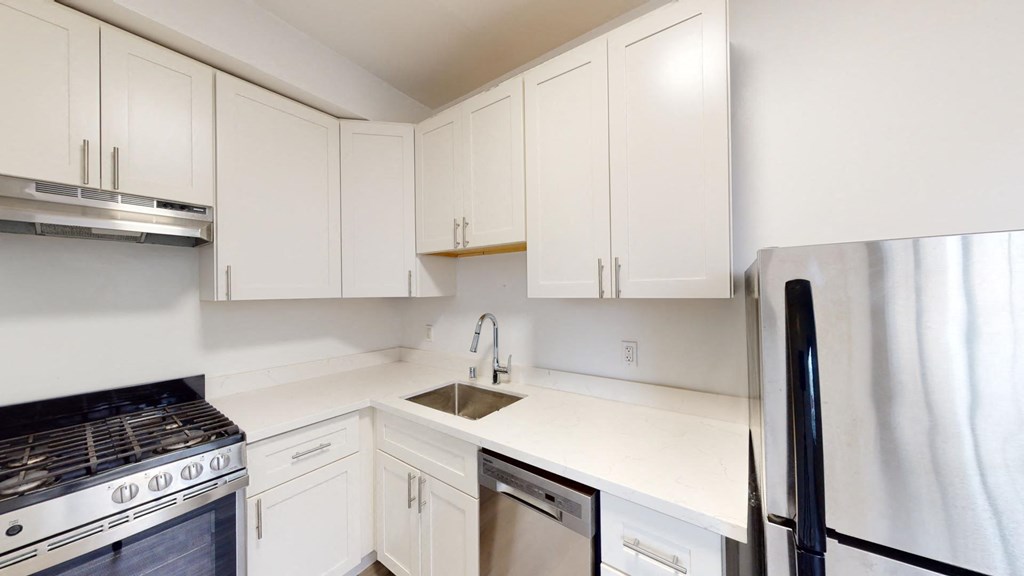 a white kitchen with white cabinets and stainless steel appliances