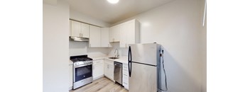 a kitchen with white cabinets and a refrigerator