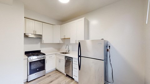 a kitchen with white cabinets and a refrigerator