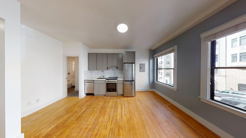 A kitchen with wooden floors and white walls.