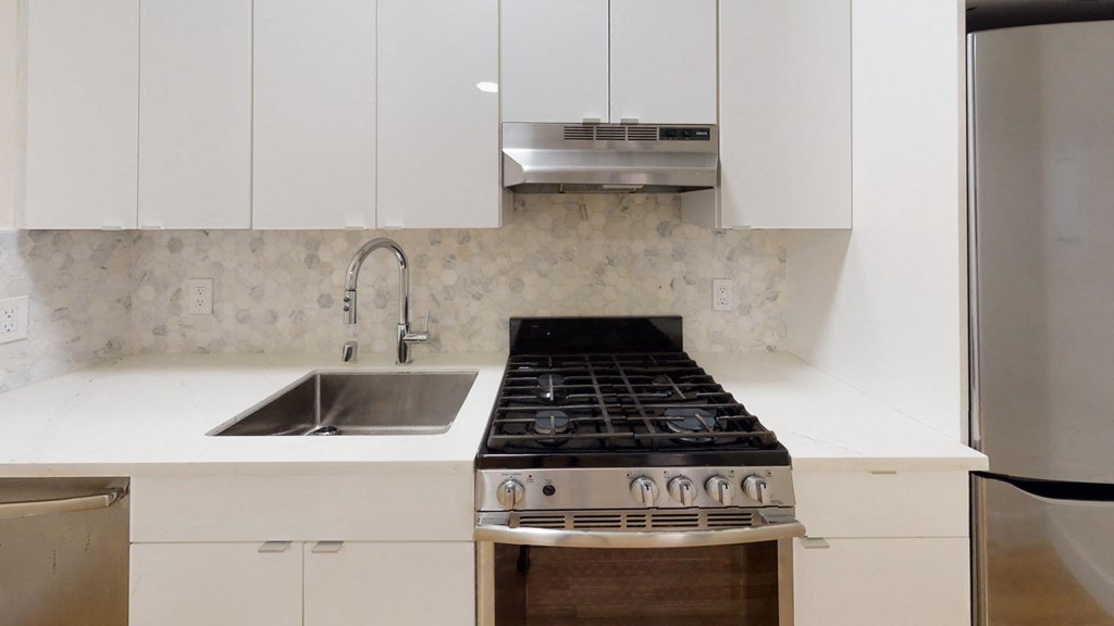 a white kitchen with a stove and a sink