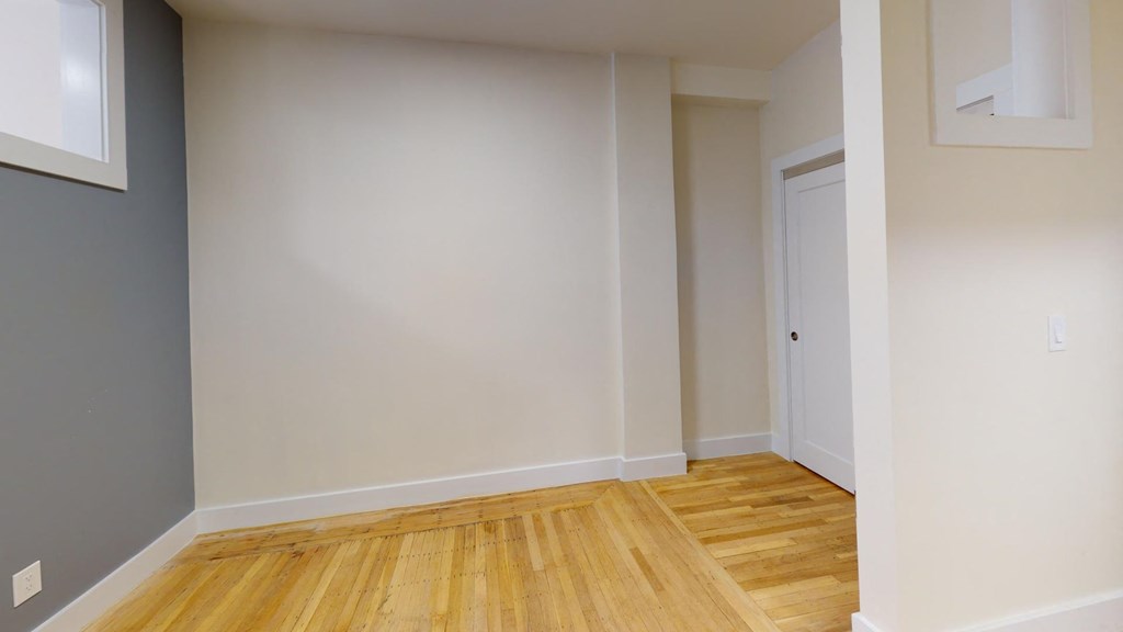 a living room with a wooden floor and a white door