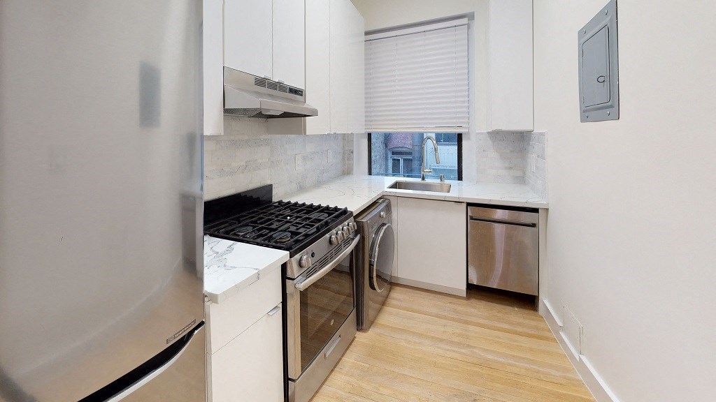 a kitchen with stainless steel appliances and white cabinets
