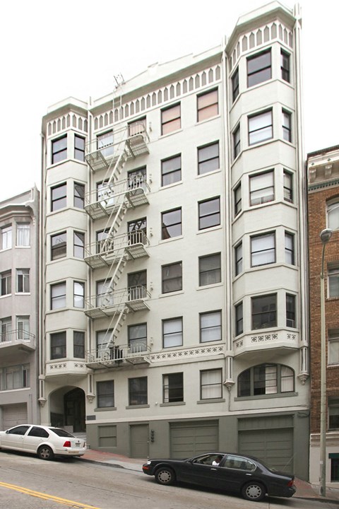 a white building with a fire escape on a city street