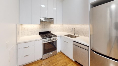 a kitchen with white cabinets and stainless steel appliances