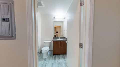 A bathroom with a toilet, sink and cabinet.