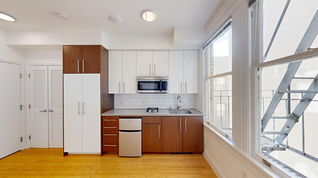 A kitchen with wooden floors and white walls.
