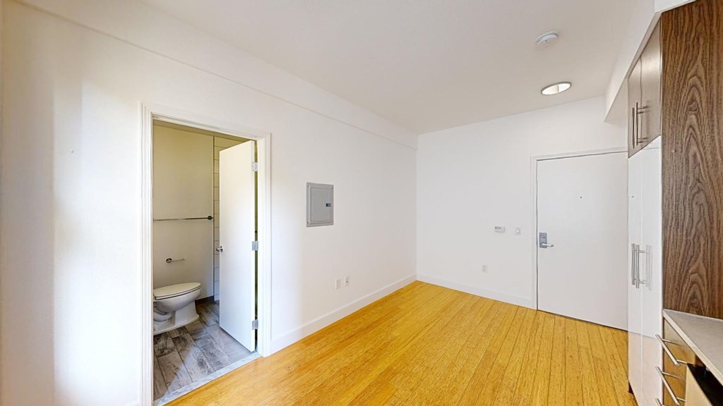 A room with a toilet and a sink is visible through an open door.