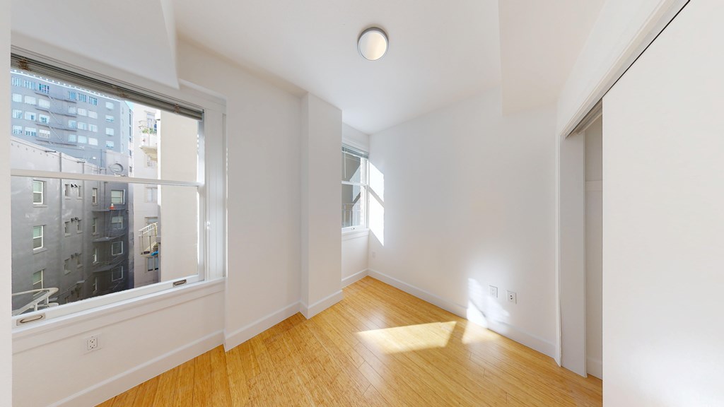 A room with a window and wooden floors.