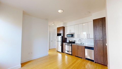 A kitchen with wooden floors and white walls.