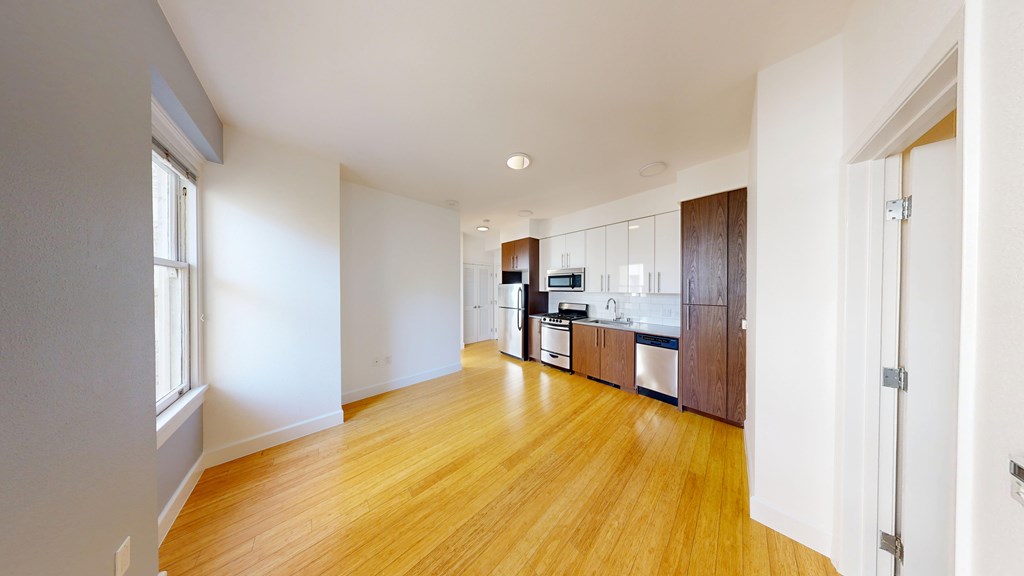 A kitchen with wooden floors and white walls.