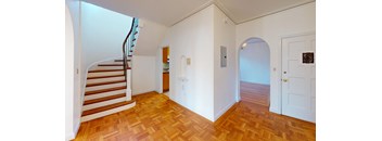 a renovated living room with a staircase and wood floors