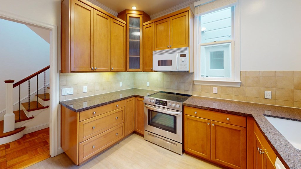 a kitchen with wooden cabinets and stainless steel appliances