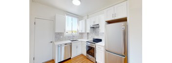 a renovated kitchen with white cabinets and stainless steel appliances