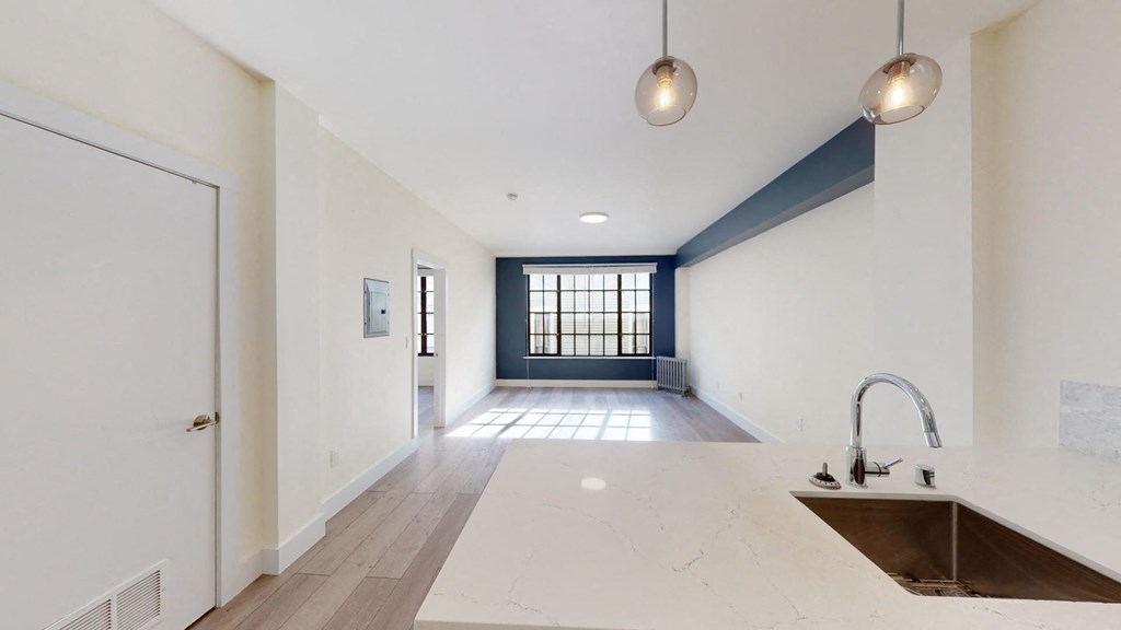 a white kitchen with a sink and a window
