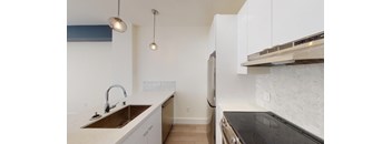 a kitchen with white cabinets and a sink and a refrigerator