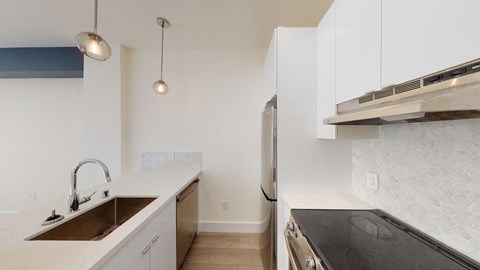 a kitchen with white cabinets and a sink and a refrigerator