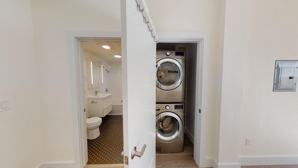a bathroom with a washing machine and a toilet in it