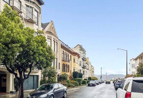 a city street with cars parked on the side of the road