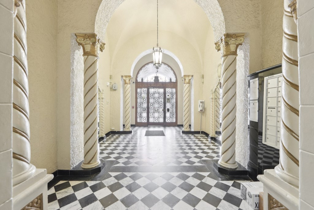 Hallway is illuminated by a chandelier hanging from the ceiling, casting a warm glow