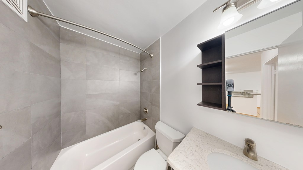 A bathroom with a white tub and a white toilet.