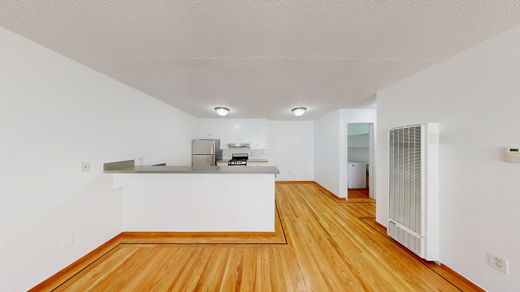 A kitchen with wooden floors and white walls.