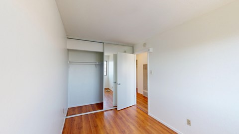 A room with a white wall and a wooden floor.