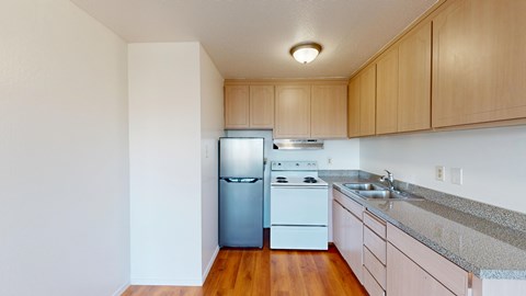 A kitchen with a white fridge, white stove, and wooden cabinets.